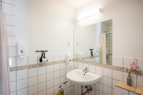 a white bathroom with a sink and a mirror at Hotel Sleep2Night in Helsingør