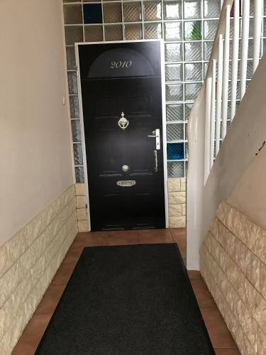 a black door in a hallway with a black rug at Suite Edin in Maintal