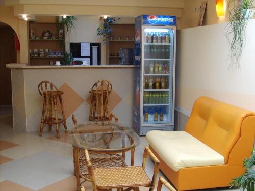 um bar com cadeiras, uma mesa e um refrigerador de bebidas em Apart Hotel Hetodon em Sozopol