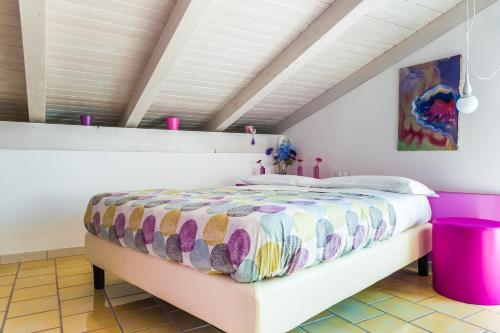 a bedroom with a large bed with a colorful comforter at Settessenze Residence & Rooms in Agropoli
