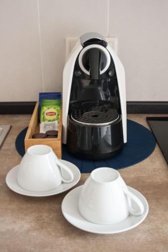 a black and white coffee maker and two white plates at Nations Porto - Studios & Suites in Porto