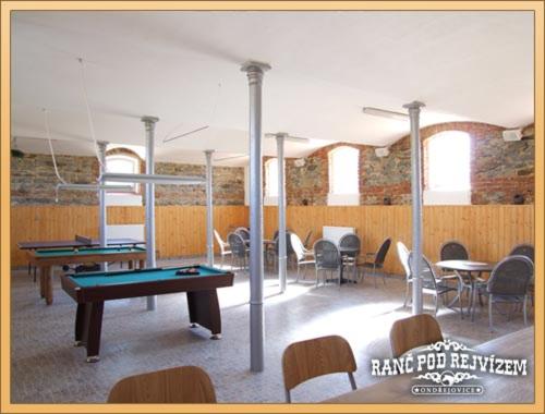 a room with ping pong tables and chairs at Ranc pod Rejvizem in Zlaté Hory