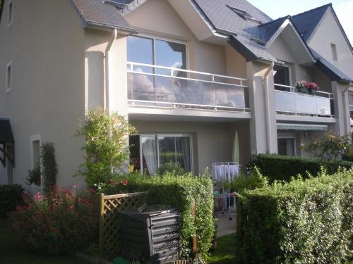 Cette maison blanche dispose d'un balcon et de quelques buissons. dans l'établissement Appartement à 3 minutes de Dinard, à La Richardais