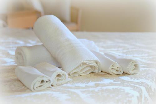 eine Gruppe von gewalzten Handtüchern auf einem Bett in der Unterkunft Hotel Ristorante Miralago in Garda