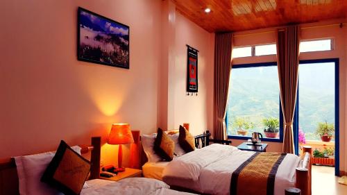 a bedroom with two beds and a large window at Sapa Odyssey Hostel in Sa Pa