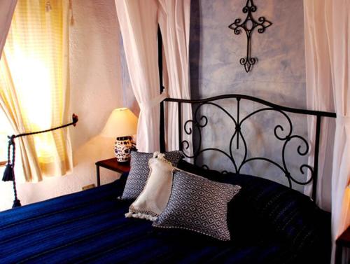 a bedroom with a black bed with a blue comforter at Hotel Casa Madeleine B&B & Spa in Antigua Guatemala