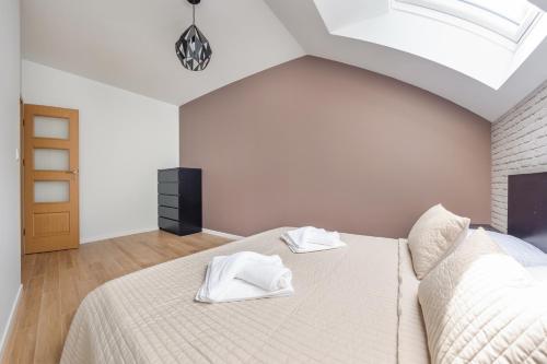 a bedroom with a bed with white towels on it at Dwie Sosny z sauną, Sun & Snow in Ustronie Morskie