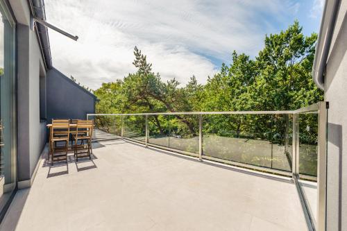 a balcony with chairs and a view of trees at Dwie Sosny z sauną, Sun & Snow in Ustronie Morskie