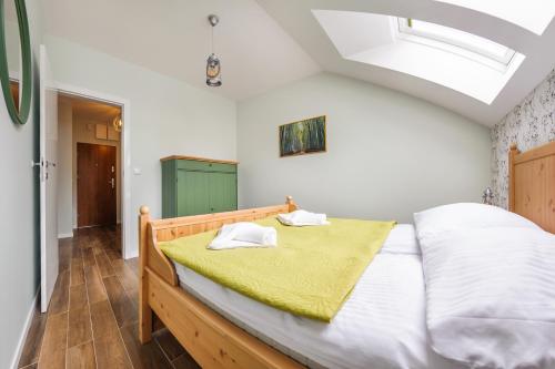 a bedroom with a large bed with a yellow blanket at Dwie Sosny z sauną, Sun & Snow in Ustronie Morskie