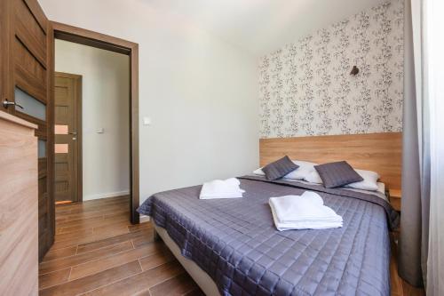 a bedroom with a bed with towels on it at Dwie Sosny z sauną, Sun & Snow in Ustronie Morskie