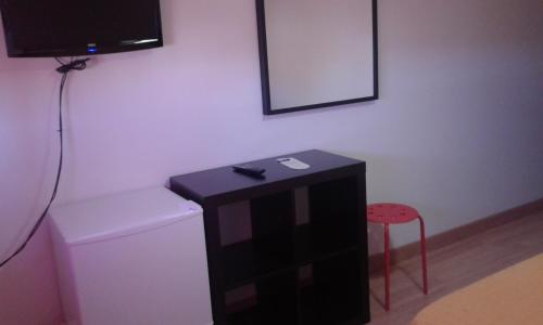 a bathroom with a toilet and a tv on a wall at Caminito ARG in La Bañeza