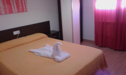 a hotel room with a towel animal on a bed at Caminito ARG in La Bañeza