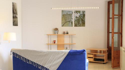 a living room with a blue couch and a table at Cal Fasi in Torá de Rulbregos