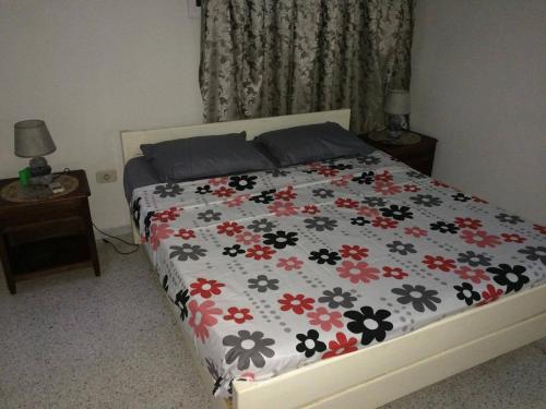 1 Schlafzimmer mit einem Bett mit Blumendecke in der Unterkunft Maison Dhiefa in Midoun