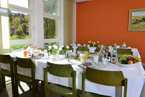 een eetkamer met een tafel met witte tafels en stoelen bij Tagungszentrum Schmerlenbach in Hösbach