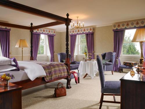 a bedroom with a bed and a table and chairs at Faithlegg Hotel in Waterford
