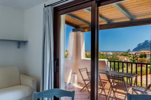 a room with a balcony with a table and chairs at La terrazza su Tavolara in Porto San Paolo