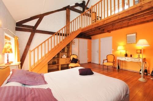 ein Schlafzimmer mit einem großen Bett und einer Treppe in der Unterkunft Chambre d'Hotes de la Loge in Moussy