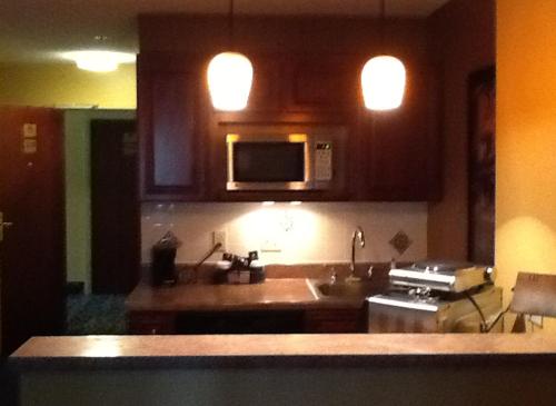 a kitchen with a sink and a microwave at Ramada by Wyndham Catlettsburg Ashland in Catlettsburg