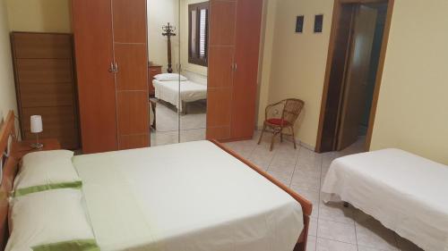 マティーノにあるAppartamento Solepinetaのベッド2台とバスルームが備わる小さな客室です。