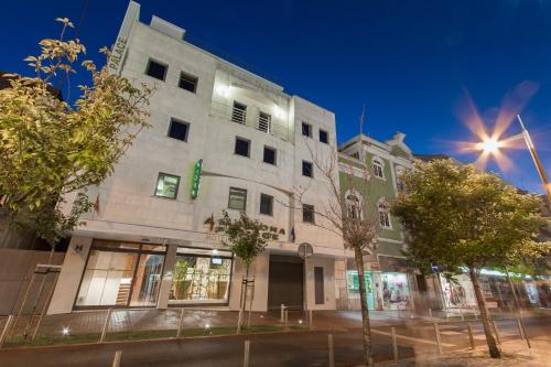 un bâtiment situé dans une rue de la ville la nuit dans l'établissement Hotel Amadora Palace, à Amadora