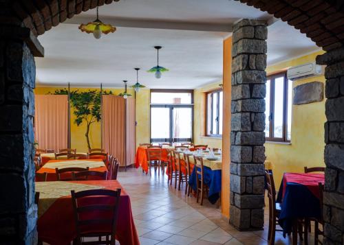 a restaurant with tables and chairs in a room at Agriturismo Le Vigne Ducali in Màndas