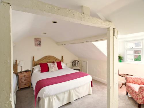 a bedroom with a large bed and a chair at Ammonite Lodge in Chard