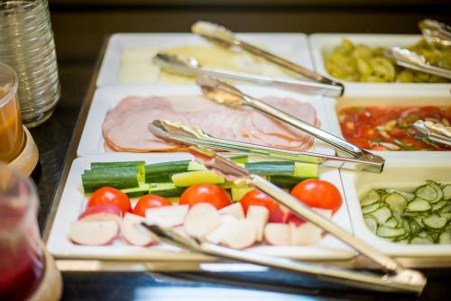 a table with three trays of different types of food at Aquaticum Debrecen Termal & Wellness Hotel in Debrecen