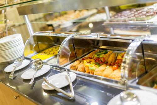 a buffet line in a restaurant with food at Aquaticum Debrecen Termal & Wellness Hotel in Debrecen