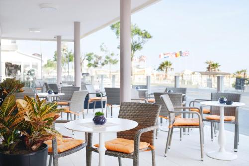 an outdoor seating area with tables and chairs at Hotel Holiday Beach in Rimini