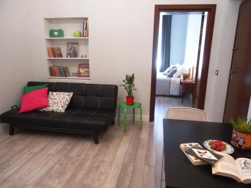 sala de estar con sofá negro y mesa en Le Volute al Pigneto, en Roma