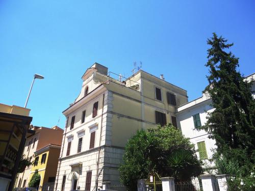 un edificio blanco alto con un árbol delante de él en Le Volute al Pigneto, en Roma