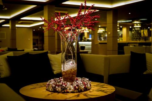 a vase filled with red flowers on a table at Aquaticum Debrecen Termal & Wellness Hotel in Debrecen