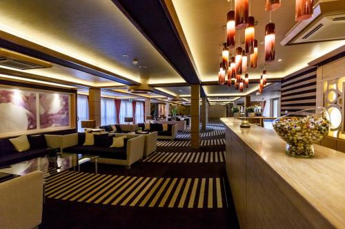 a hotel lobby with a bar and couches at Aquaticum Debrecen Termal & Wellness Hotel in Debrecen