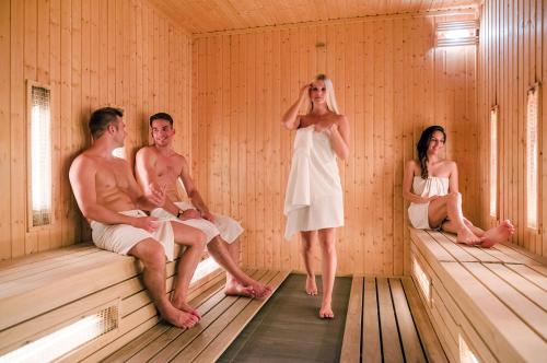 a group of people sitting in a sauna at Aquaticum Debrecen Termal & Wellness Hotel in Debrecen