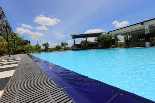 a large blue swimming pool next to a building at Eco Hotel Black & White - Anuradhapura in Mihintale