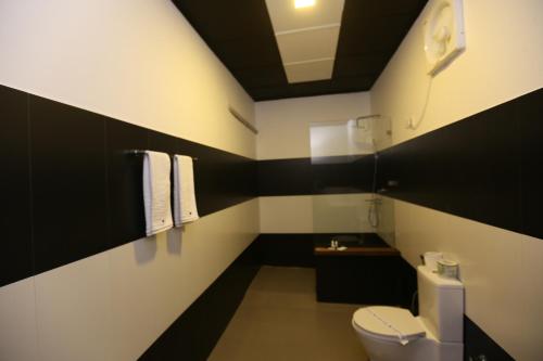 a black and white bathroom with a toilet and a sink at Eco Hotel Black & White - Anuradhapura in Mihintale