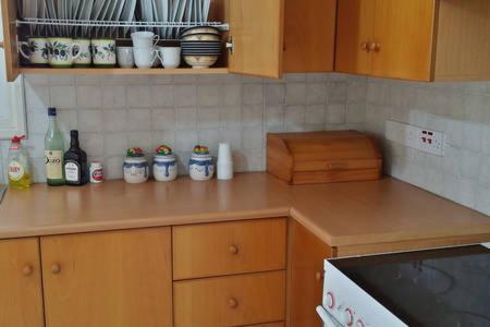 a kitchen with a counter top with bottles and dishes at Larnaka Beach House 3 in Larnaka