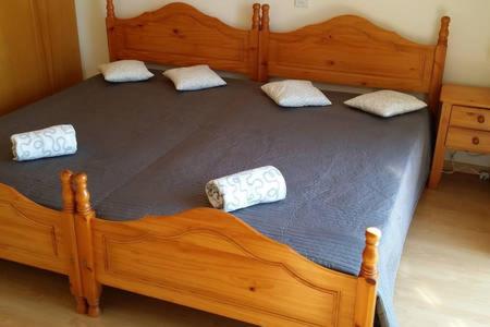 a large wooden bed with two pillows on it at Larnaka Beach House 3 in Larnaka