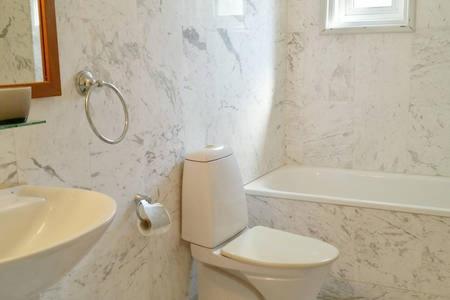 a white bathroom with a toilet and a sink at Larnaka Beach House 3 in Larnaka