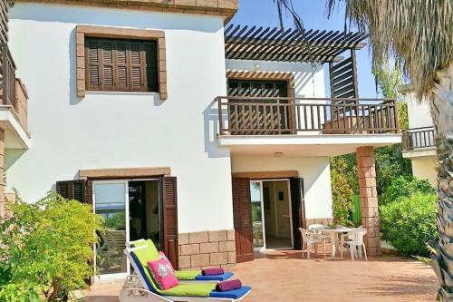 a patio with chairs and a table in front of a house at Larnaka Beach House 3 in Larnaka