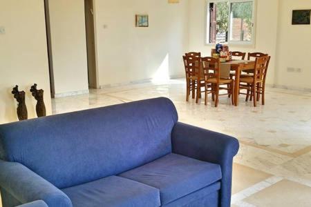 a blue couch in a living room with a table at Larnaka Beach House 3 in Larnaka