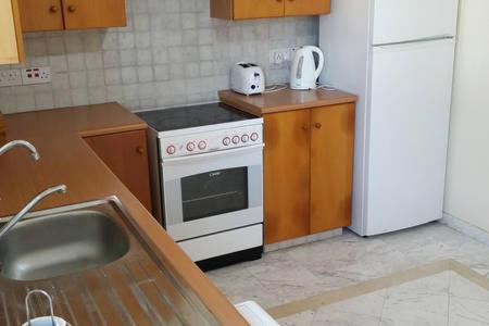 a kitchen with a white stove and a refrigerator at Larnaka Beach House 3 in Larnaka