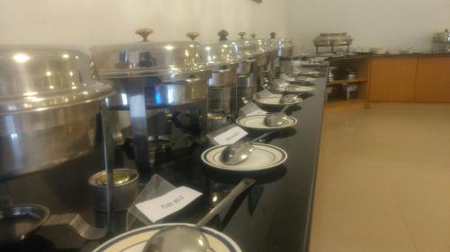 a row of stainless steel tanks in a kitchen at Abad Harmonia Ayurvedic Beach Resort in Kovalam