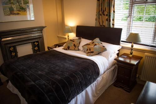 a bedroom with a large bed and a fireplace at Claverton Hotel in Battle
