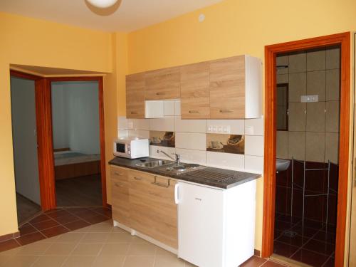 a kitchen with a sink and a microwave at Liliom Apartman in Gyula