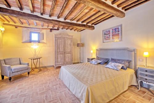 1 dormitorio con 1 cama y 1 silla en La Fonte by PosarelliVillas, en Cortona