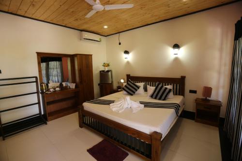 a bedroom with a large bed in a room at Eco Hotel Black & White - Anuradhapura in Mihintale