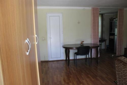 a room with a table and a chair and a door at Nunuka House in Tserovani
