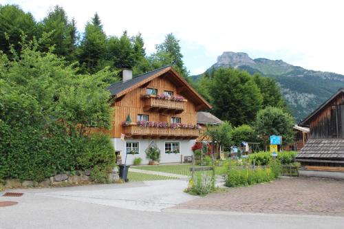 a wooden house with a balcony with flowers on it at Ferienwohnung Leuner in Altaussee